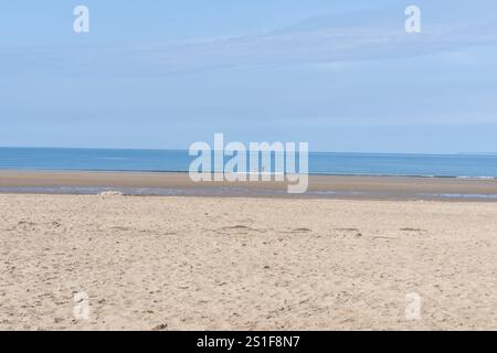 Harlech Wales - 1. August 2024; weitläufiger Blick auf den malerischen Harlech Beach Vater und Sohn in der Ferne im Wasser jenseits des Sandes bis zum Ufer und Horizont in No Stockfoto