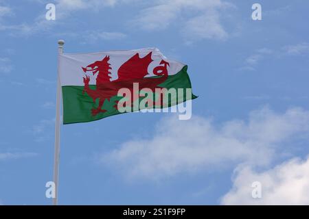 Die Flagge von Wales mit dem roten Drachen weht hoch im Wind. Stockfoto