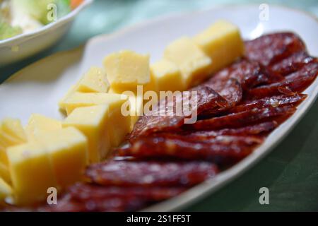 Wurstscheiben auf Holzbrett mit verschiedenen Snacks. Tapas. Stockfoto