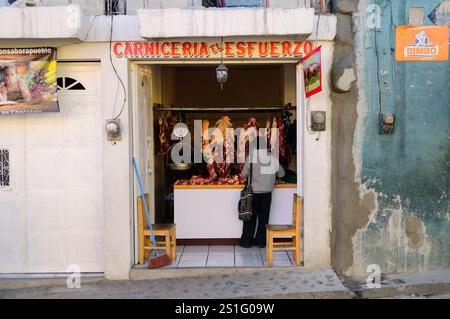 Metzgerei Chichicastenango Guatemala // CHICHICASTENANGO, Guatemala — Eine kleine Metzgerei in der indigenen Maya-Stadt Chichicastenango (auch bekannt als Chichi) im guatemaltekischen Hochland. Die Stadt, etwa 90 Meilen (145 km) nordwestlich von Guatemala City auf einer Höhe von fast 6.500 Fuß (1.980 Meter), dient als wichtiges Handelszentrum für die K'iche' Maya. Chichicastenango ist bekannt für seine lebhaften, zweimal wöchentlichen Märkte, die donnerstags und sonntags stattfinden und sowohl Einheimische als auch Touristen auf der Suche nach traditionellen Waren und Speisen anlocken. Stockfoto