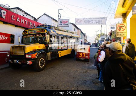 Bus in Chichicastenango Guatemala // CHICHICASTENANGO, Guatemala - Leute warten auf den Bus in Chichi. Chichicastenango ist eine indigene Maya-Stadt im guatemaltekischen Hochland, etwa 90 Meilen nordwestlich von Guatemala City und auf einer Höhe von fast 6.500 Metern. Am bekanntesten ist es für seine sonntäglichen und donnerstags stattfindenden Märkte. Stockfoto