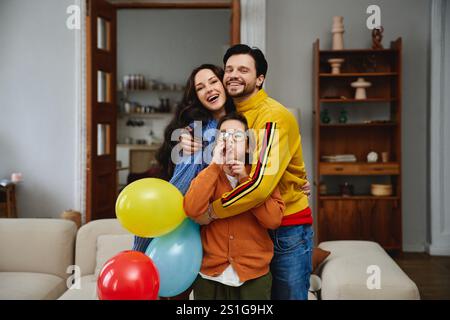 Glückliche Familie, die einen besonderen Anlass mit bunten Ballons im Haus feiert Stockfoto