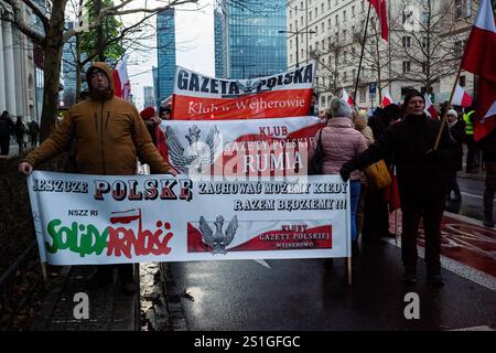 Die Demonstranten halten vor Beginn des demonstrationsmarsches Banner. Am Nachmittag des 3. Januar, während des feierlichen Beginns des polnischen Ratsvorsitzes in der EU, versammeln sich polnische Landwirte und andere Landarbeiter in Warschau, um zu protestieren. Während Ursula von der Leyen Polen zur Eröffnungsgala im Nationaltheater besucht, treffen sich die Demonstranten im Gebäude der Europäischen Kommission und marschieren durch die Straßen zum Theater. Die Demonstranten haben fünf Forderungen: Lebensmittelimporte aus den Mercosur-Ländern zu stoppen, den Grünen Deal zu stoppen, Importe aus der Ukraine zu stoppen, die Demstruk zu stoppen Stockfoto