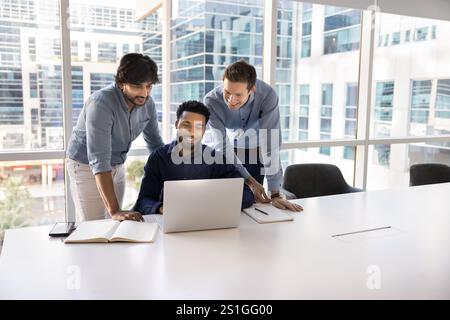 Vielfältige Gruppe von drei Geschäftskollegen, die sich am Laptop treffen Stockfoto