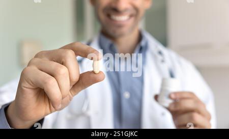 Hände eines positiven männlichen Arztes, der Pille und Flasche hält Stockfoto