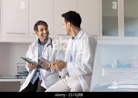 Glückliche erfolgreiche Ärzte mittleren Alters, die Tablette halten Stockfoto