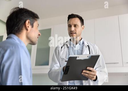 Ernsthafter Hausarzt, Kardiologe Mann, der mit dem Patienten spricht Stockfoto
