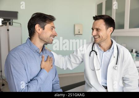 Glücklicher, dankbarer Mann, der einen Arzt berät und Unterstützung bekommt Stockfoto