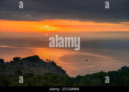 Sonnenaufgang am Cap de Creus, in der Nähe von Roses, mit einem Boot im Meer, an der Costa Brava (Alt Empordà, Girona, Katalonien, Spanien) ESP: Amanecer en el Cabo de Creus Stockfoto