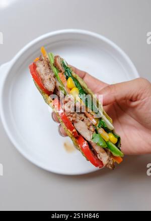 Tortilla-Wrap mit gebratenem Huhn und Gemüse. Stockfoto