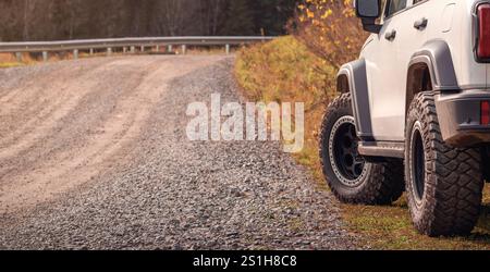 Autotourismus und Reisen - Abenteuer im Gelände Herausforderungen Sie sich in der Herbstsaison mit einem Geländewagen auf einer rauen Schotterstraße. Stockfoto