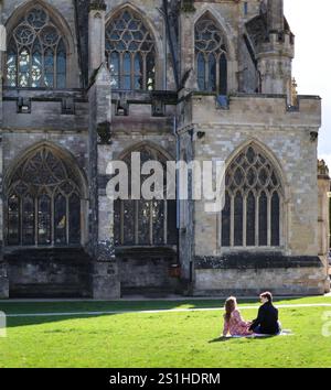 Ein junges Paar, das auf einem Kathedralengarten in Exeter, devon, großbritannien picknickt Stockfoto