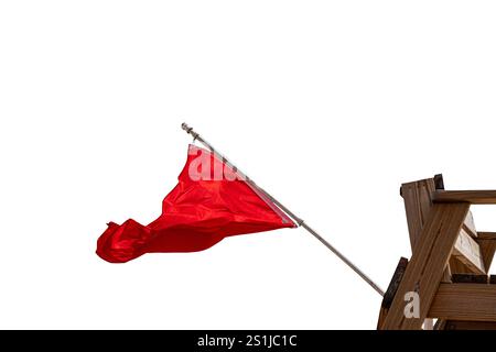 Rote Flagge winkt im Wind von einem hölzernen Rettungsschwimmerstuhl auf weißem Hintergrund Stockfoto