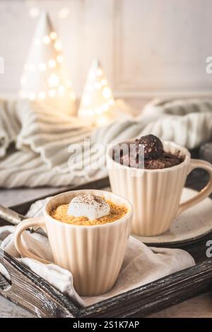 Kürbisgewürz und Schokolade Becher Kuchen auf cremeweißem gemütlichem Hintergrund mit weihnachtsdekoration, vertikal mit Kopierraum Stockfoto