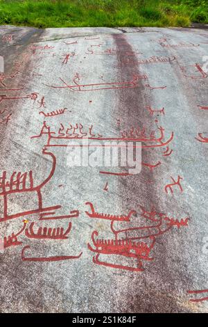 Die Rote Malerei der Tanum-Felsritzereien auf dem Vitlycke-Flachfelsen zeigt Boote, Menschen und Tiere aus der Bronze- und Eisenzeit. Stockfoto
