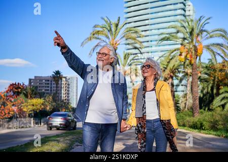 Glückliches Seniorenpaar, das in barcelona spaziert und den Urlaub genießt. Stockfoto