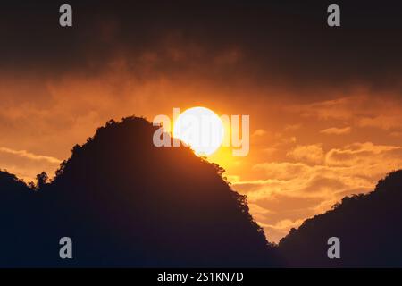 Wunderschöner lebhafter Sonnenuntergang mit orangefarbenem Himmel über dem Silhouette Berg Stockfoto