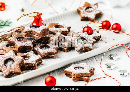 Traditionelle Linzer Weihnachtskekse gefüllt mit Quittenmarmelade auf weißem Holzhintergrund, christliche Dekoration Stockfoto