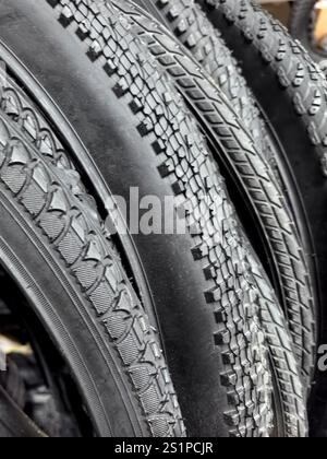 Eine Nahansicht erfasst die komplexen Muster der Reifenprofilstreifen, die sich zusammenlagern, und zeigt das Bewegungsdesign und die Haltbarkeit jedes Reifens als Lichtreflexion Stockfoto