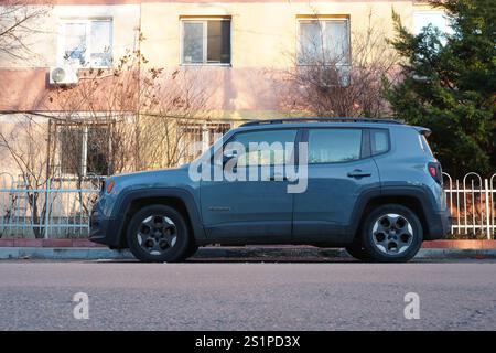 Bukarest, Rumänien – 1. Januar 2025: Seitenansicht des grauen Jeep Renegade Longitude Autos, der auf der Straße vor dem Wohnblock geparkt ist Stockfoto