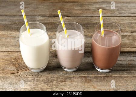 Verschiedene leckere Proteincocktails in Gläsern auf Holztisch Stockfoto