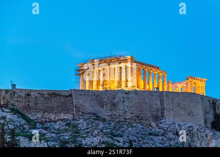 Beleuchtetes Parthenon bei Nacht vor einem leuchtenden blauen Himmel in Athen Stockfoto