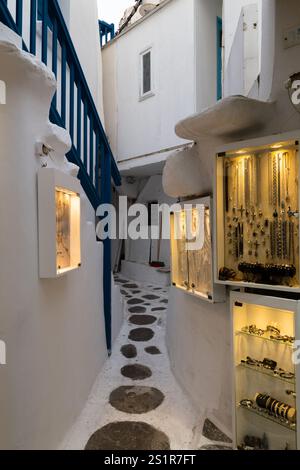 Charmante schmale Gasse mit Schmuckausstellung in einem traditionellen mediterranen Dorf, Mykonos, Griechenland Stockfoto