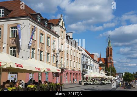 Farbenfrohe historische Häuser und ein Kirchturm mit Straßencafés unter blauem Himmel, Kosciuszko Marktplatz, Kirche der Heiligen Jungfrau Maria, BiaNys Stockfoto