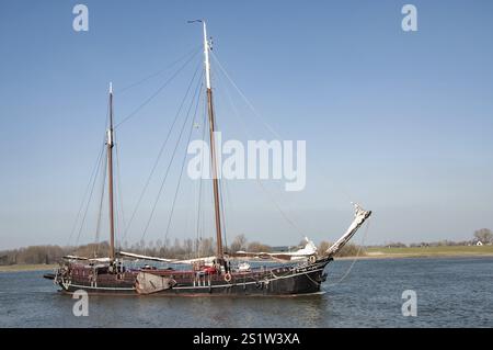 Traditioneller niederländischer Segel-Fracht-Tjalk mit zwei Masten, die auf ruhigem Wasser unter blauem Himmel in den niederlanden segeln Stockfoto