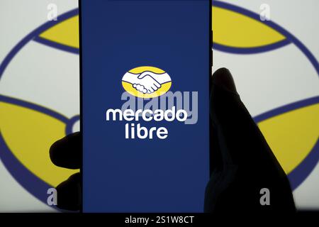 Mobiltelefon mit Logo des argentinischen E-Commerce-Unternehmens Mercado Libre Inc. Auf dem Bildschirm vor der Business-Website. Konzentrieren Sie sich auf die Mitte des Telefondisplays. Stockfoto