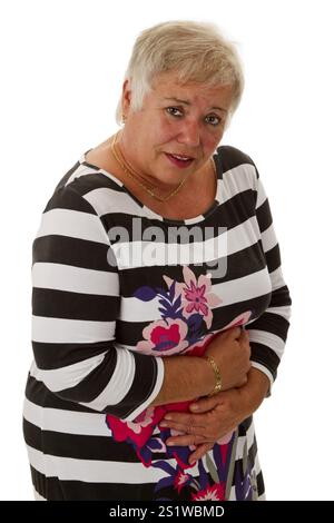 Ältere Frau, die ihre Hände vor dem Bauch hält - abgeschnitten auf weißem Hintergrund Stockfoto