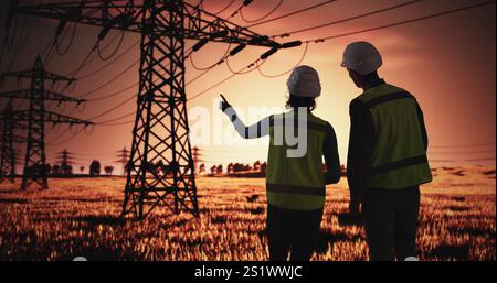 Elektriker Sprechen In Der Nähe Von Hochspannungs-Leitungsturmen Stockfoto