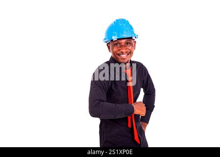 Porträt eines jungen männlichen Ingenieurs, der einen blauen Schutzhelm trägt, während er in die Kamera lächelt. Stockfoto