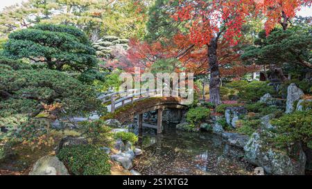 Eine ruhige Szene einer Holzbrücke über den Onnai-Teich am Kaiserpalast von Kyoto, umgeben von üppigem Grün und herbstlichen Farben. Eine friedliche Oase. Kyo Stockfoto