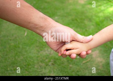 Asiatisches Baby Hände auf Vaterhand Stockfoto