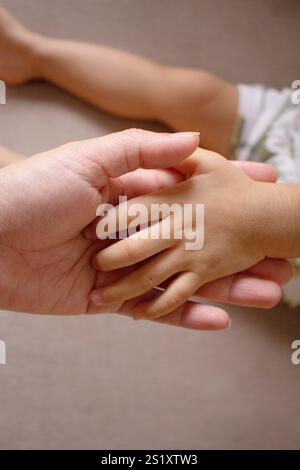 Babyhände in der Mutterhand Stockfoto