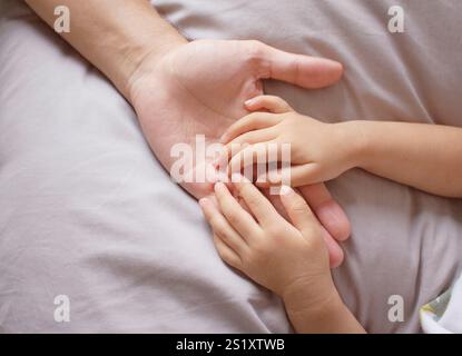 Babyhände in Vaterhand Stockfoto