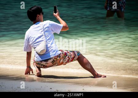 Touristen schwärmen das ikonische türkisfarbene Wasser der Maya Bay: Eine lebhafte Szene mit Selfies, Posen und überfüllten Ufern - „The Beach“ mit Leonardo DiCaprio Stockfoto