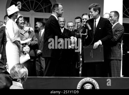 (8. Mai 1961) Präsident John F. Kennedy gratuliert dem Astronauten Alan B. Shepard Jr., dem ersten Amerikaner im Weltraum, zu seiner historischen Fahrt am 5. Mai 1961 mit dem Raumschiff Freedom 7 und verleiht ihm den NASA Distinguished Service Award. Die Zeremonie fand auf dem Rasen des Weißen Hauses statt. Shepards Frau Louise (in weißem Kleid und Hut) und seine Mutter waren anwesend, ebenso die sechs anderen Mercury-Astronauten und NASA-Büros, einige davon im Hintergrund zu sehen. Bildnummer : 1961ADM-13 Stockfoto