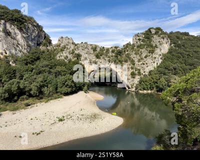 Touristen mit Kanus und Kajaks paddeln den Pont D'Arc-Bogen in den Ardeches-Schluchten, Rhone Alpes, Frankreich Stockfoto