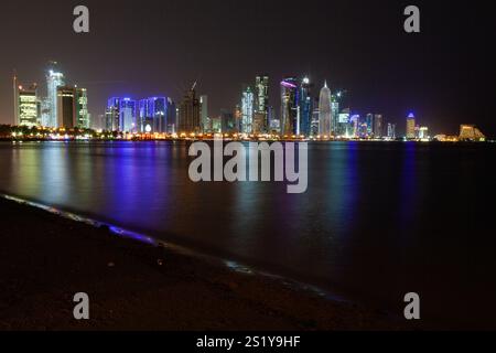 Panoramablick bei Nacht auf die West Bay in Doha. Moderne Wolkenkratzer sind von der Corniche aus zu sehen Stockfoto