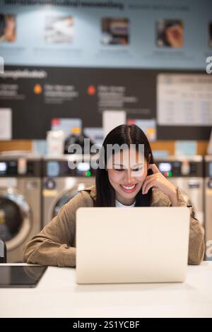 Frau, die am Laptop arbeitet, im Wäscheservice-Konzept Stockfoto