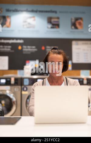 Frau, die an einem Computer arbeitet, in einem Wäscheservice-Konzept Stockfoto