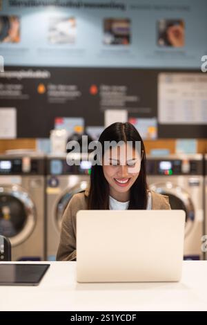 Frau, die am Laptop arbeitet, im Wäscheservice-Konzept Stockfoto