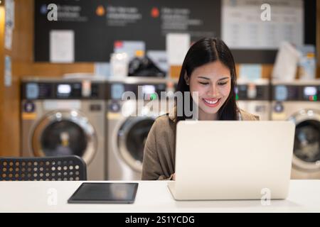 Frau, die am Laptop arbeitet, im Wäscheservice-Konzept Stockfoto