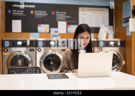 Frau, die am Laptop arbeitet, im Wäscheservice-Konzept Stockfoto