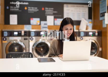 Frau, die am Laptop arbeitet, im Wäscheservice-Konzept Stockfoto