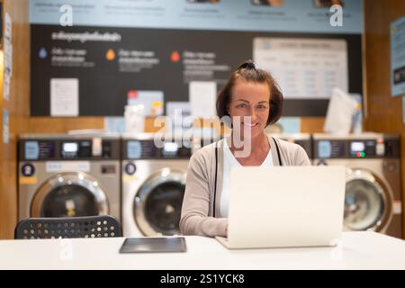Frau, die an einem Computer arbeitet, in einem Wäscheservice-Konzept Stockfoto
