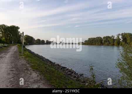 Eine friedliche Flusslandschaft mit einem unbefestigten Pfad entlang des ruhigen Flusses. Stockfoto