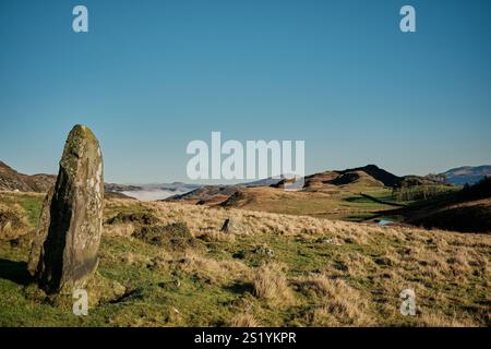 Ein stehender Stein steht aufrecht und blickt über die Seen von Cregennan, oder Llynnau Cregennan, in der Nähe von Arthog, Dolgellau und der Mawddach-Mündung in Nordwales Stockfoto